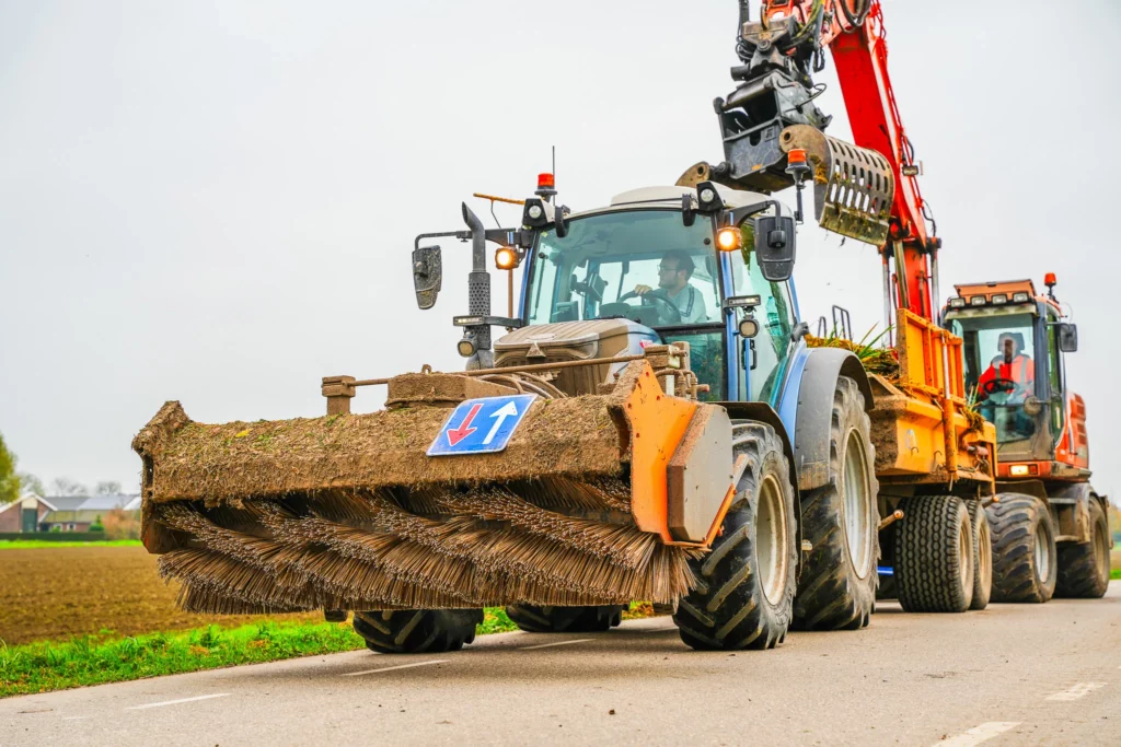 Winterwerk in de natuur: trekker chauffeur rijdt op landbouwweg